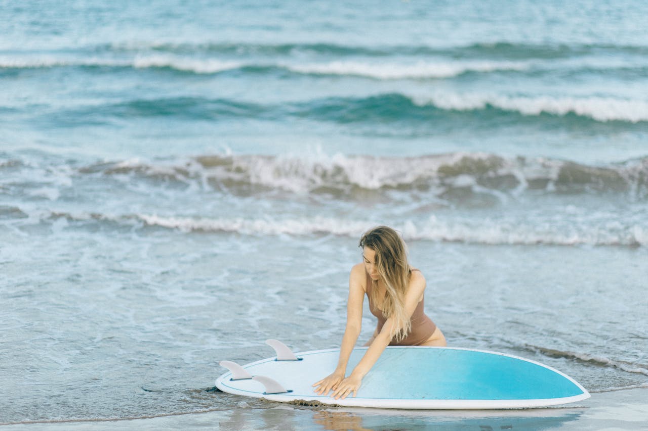 our-story Woman with a surfboard enjoying a sunny day by the ocean, perfect summer vibes.