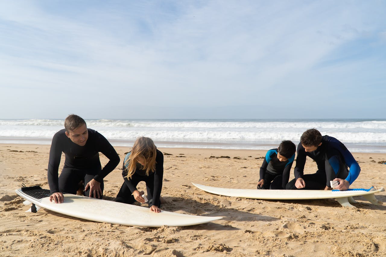 about-us Family prepares surfboards on a sunny beach in Portugal for a fun day of surfing.